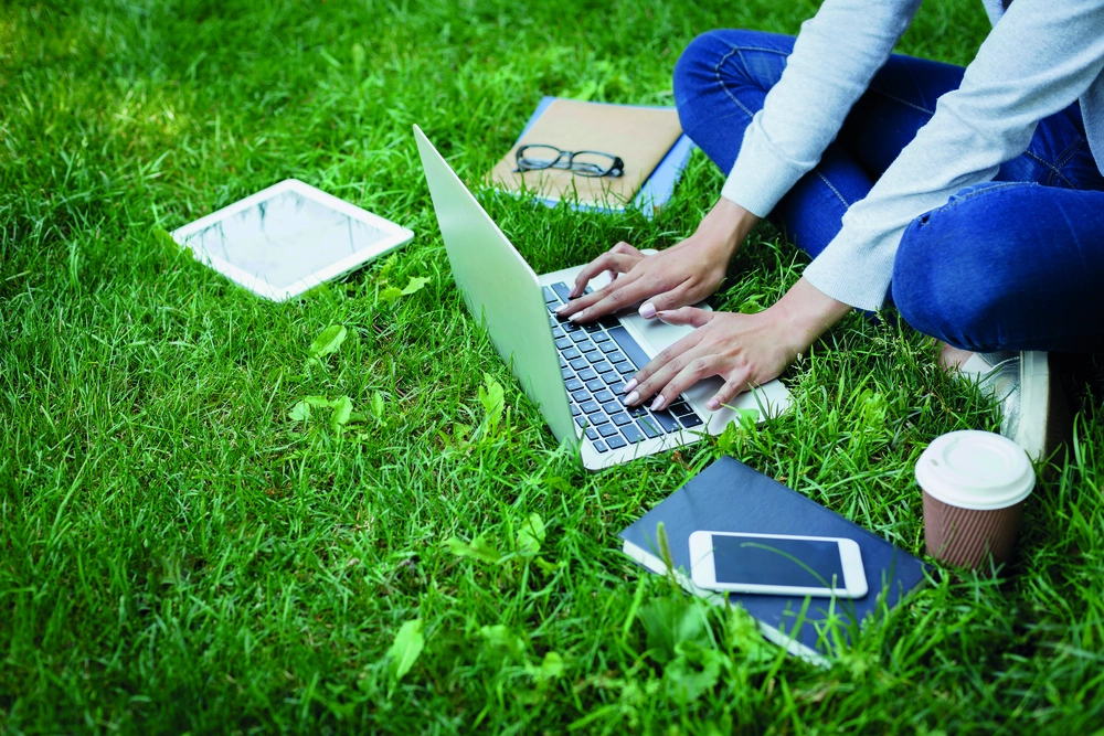 Laptop, Frau, Rasen – © Prostock-Studio_961845662 / iStock.com